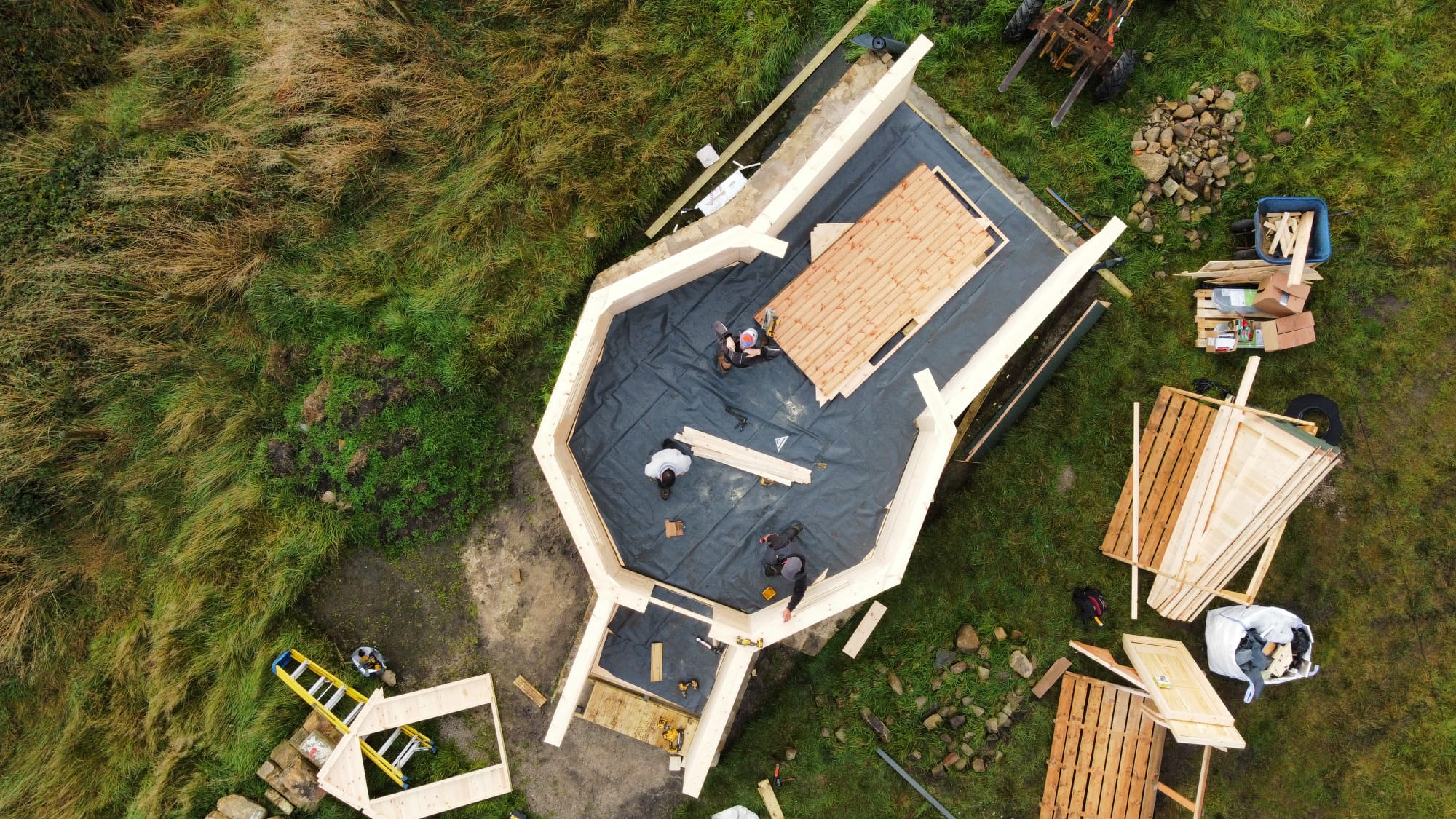 aerial shot of camping cabin being built with team of fitters